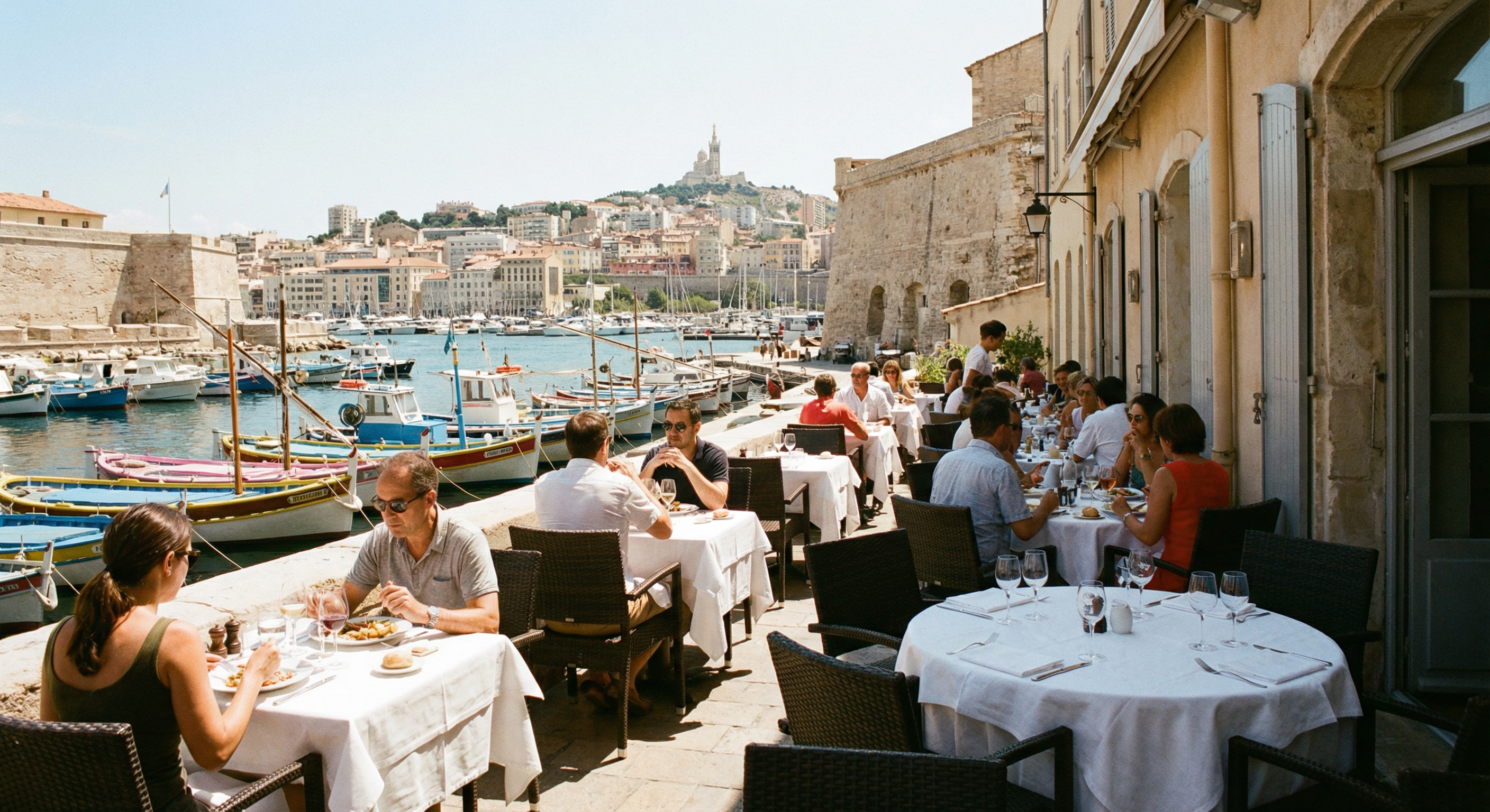 Terrasse de restaurant avec vue sur le Vieux-Port de Marseille, bateaux de pêche, Notre-Dame de la Garde