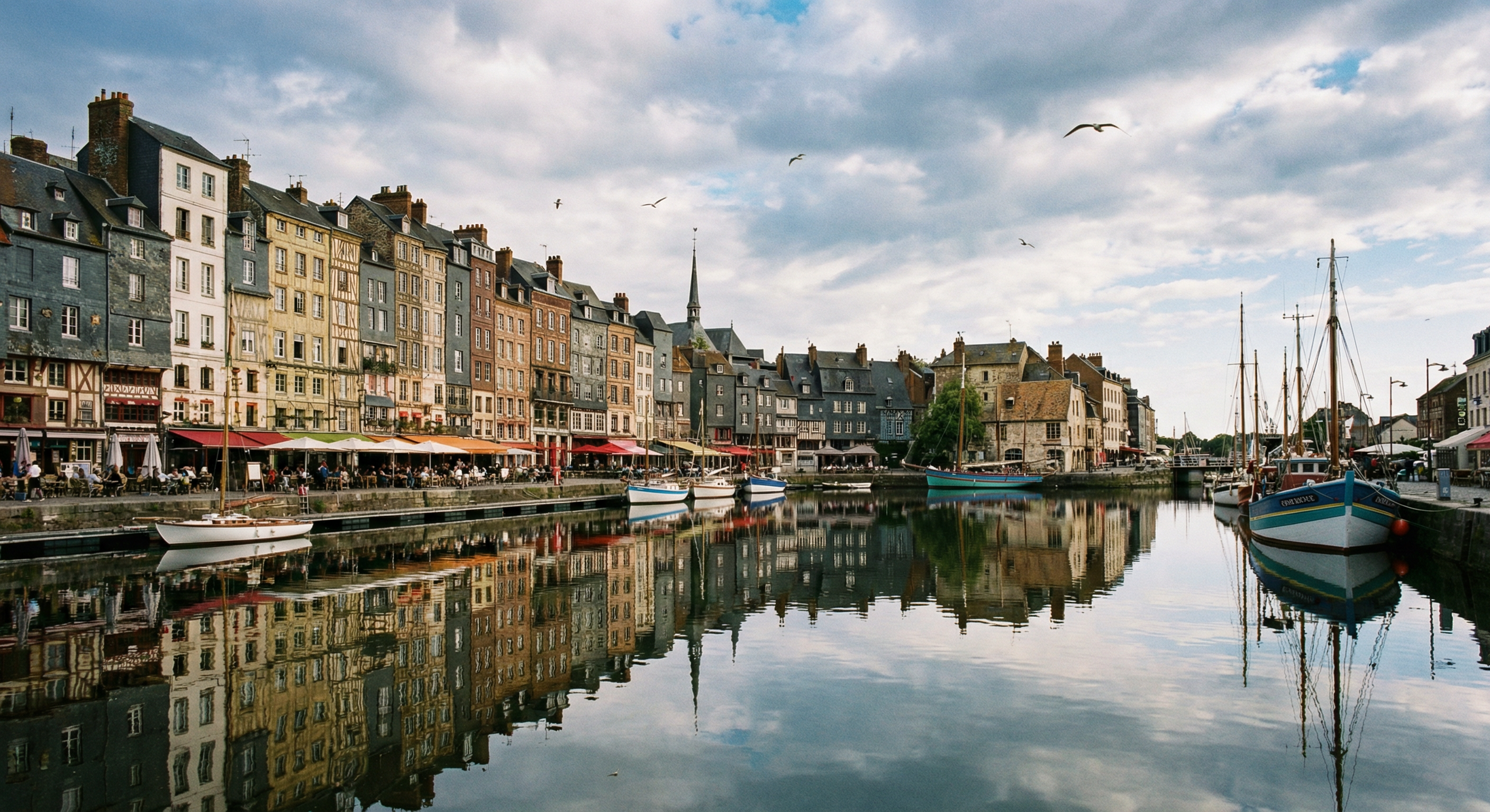 Port de Honfleur : maisons à colombages, terrasses de restaurants, bateaux de pêche, ambiance station balnéaire normande