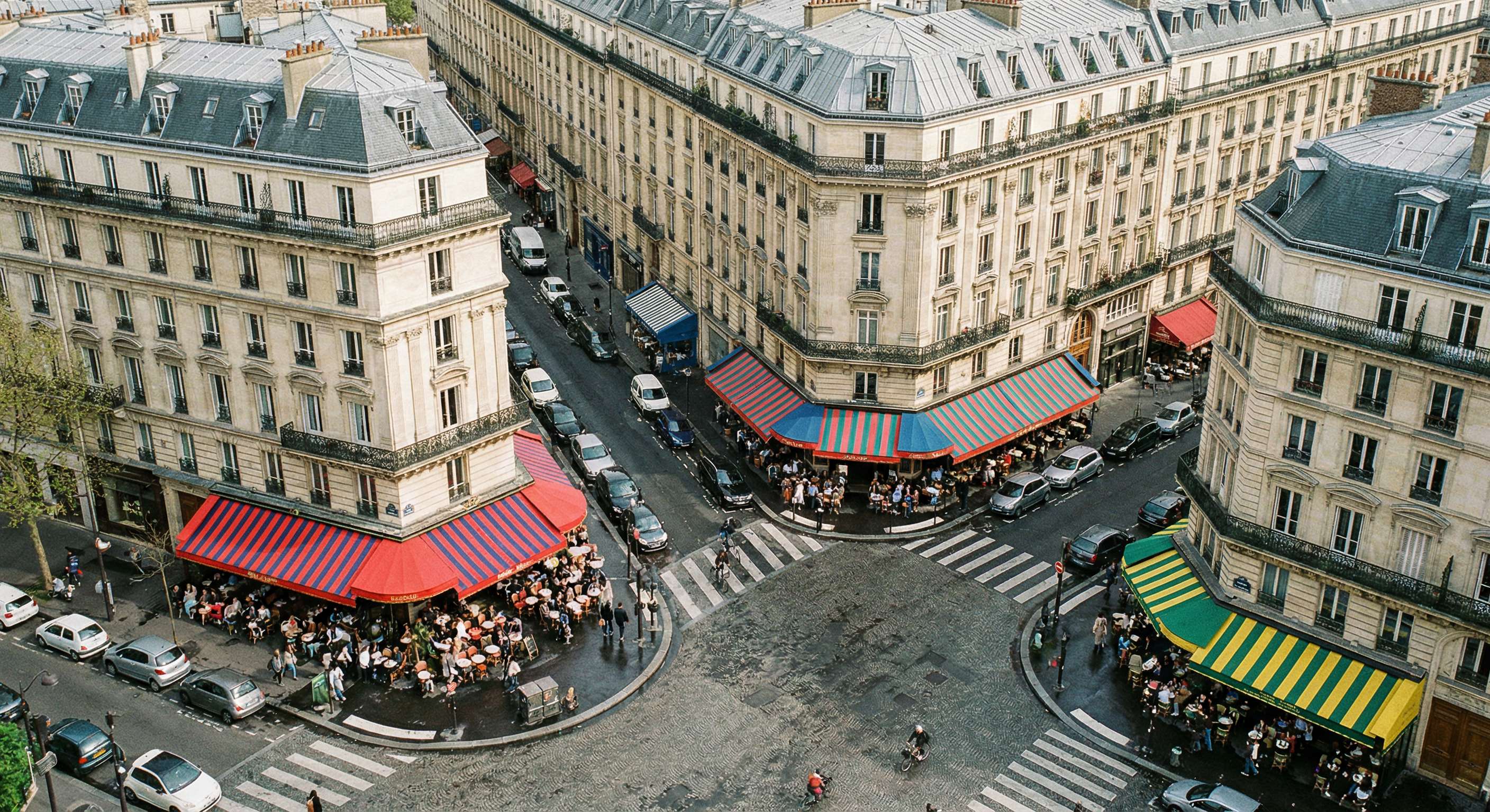 Carrefour parisien animé avec terrasses de cafés et brasseries aux coins de rue, immeubles haussmanniens